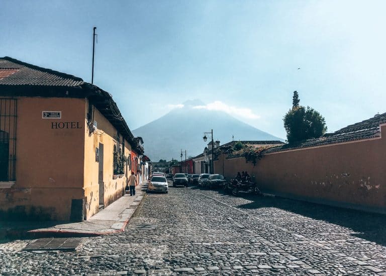 A volcano looming above the quaint cobbled streets of Antigua, Guatemala, Central America