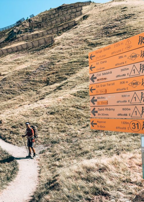 Andy hiking the Tour du Mont Blanc with signposts pointing us in the right direction, Italy