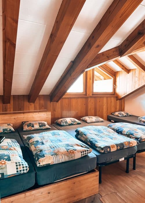 A dormitory in Rifugio Bonatti with 5 beds next to each other, Courmayeur, Aosta Valley, Tour du Mont Blanc, Italy