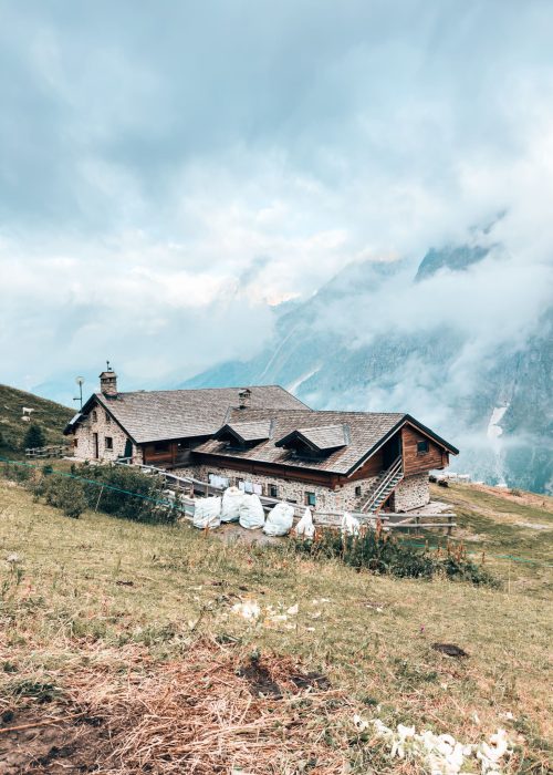 The secluded Rifugio Bonatti shrouded in cloud with mountains towering above it on the TMB, Courmayeur, Aosta Valley, Tour du Mont Blanc, Italy