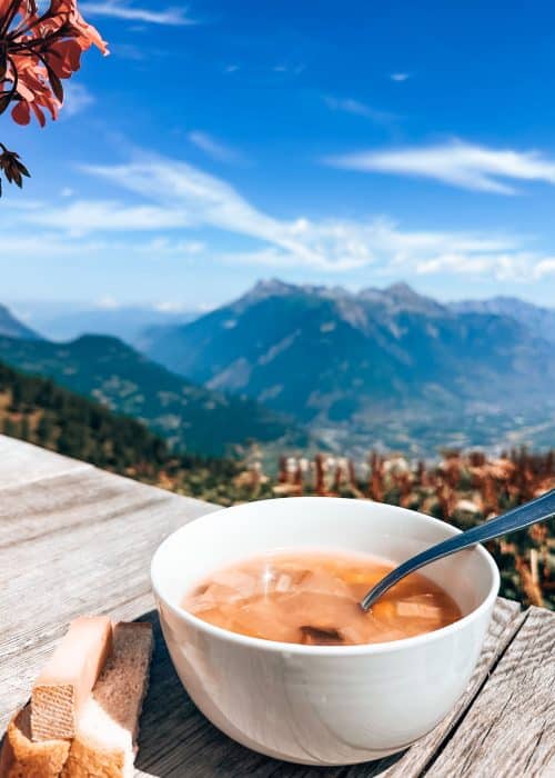 A hearty and delicious bowl of soup overlooking the valley and surrounding mountains at Alpage de Bovine while hiking the Tour du Mont Blanc, Montigny, Switzerland