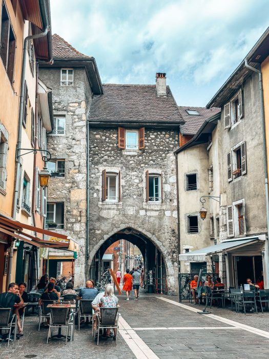 One of the gates of Annecy's old city walls with an arch over the narrow street, things to do in Annecy in summer, France