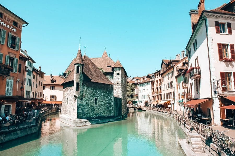 The historic Palais de l'Ile perched on a rocky island on the Thiou River in Annecy Old Town, France