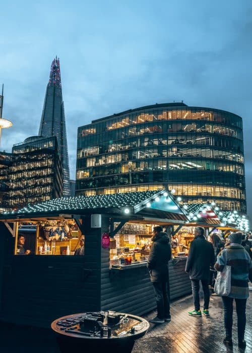 Cute cabins serving food with a backdrop of The Shard, Christmas by the River, London