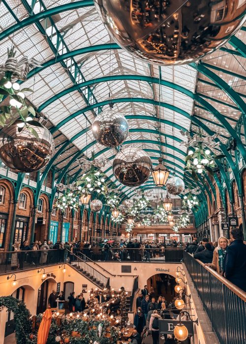 Giant silver baubles and mistletoe hanging above Apple Market in Covent Garden are some of the best Christmas decorations in London