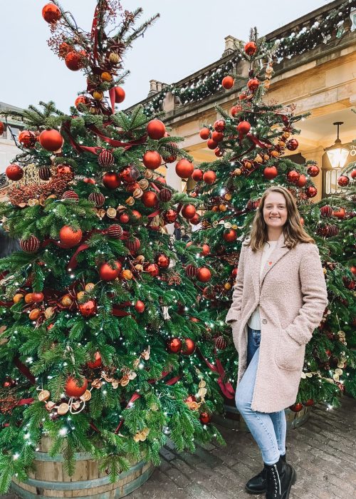 Helen stood next to Christmas trees in Covent Garden in London at Christmas 2022