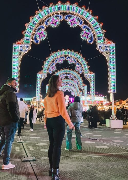 Helen stood underneath the massive vibrant sparkling light arches at Winter Wonderland in Hyde Park, London