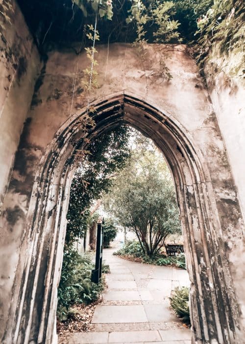 Archway with a path leading into another garden at St Dunstan in the East, London