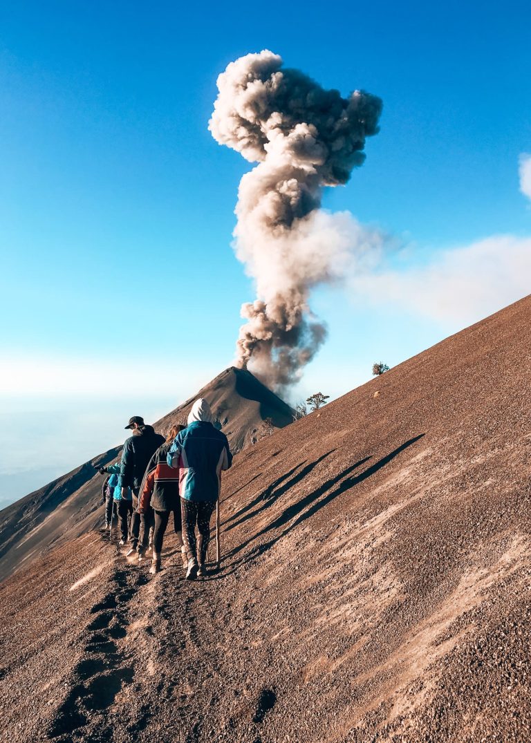 Descending on the steep scree down Acatenango Volcano as Volcan Fuego erupts in front of us, Guatemala