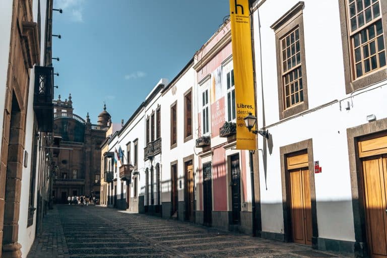 A quaint cobbled street lined with colourful buildings with the magnificent Santa Ana Cathedral at the end, Vegueta, Las Palmas, Gran Canaria