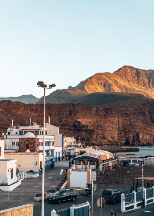 The town of Puerto de las Nieves nestled at the foothills of dramatic mountain peaks in the Tamadaba National Park one of the best places to visit in Gran Canaria, Spain