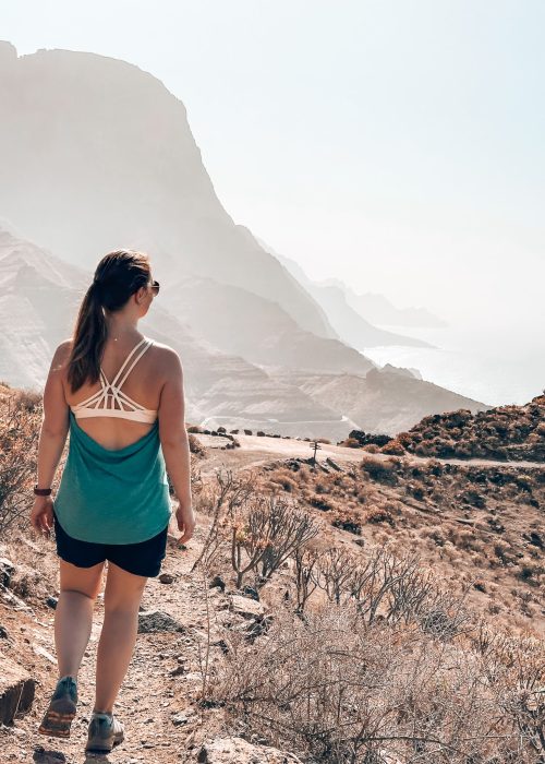Helen hiking towards dramatic cliffs plunging into the ocean in the Tamadaba National Park, Gran Canaria, Spain