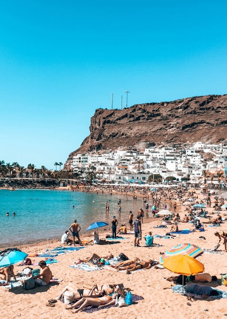 The small and sheltered Playa de Mogan full of people enjoying the sun, one of the best things to do in Gran Canaria, Spain