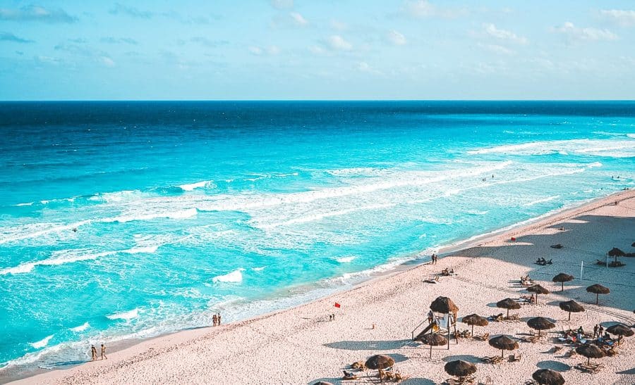 A long stretch of fine white sand with sunbeds and umbrellas on and gorgeous turquoise water