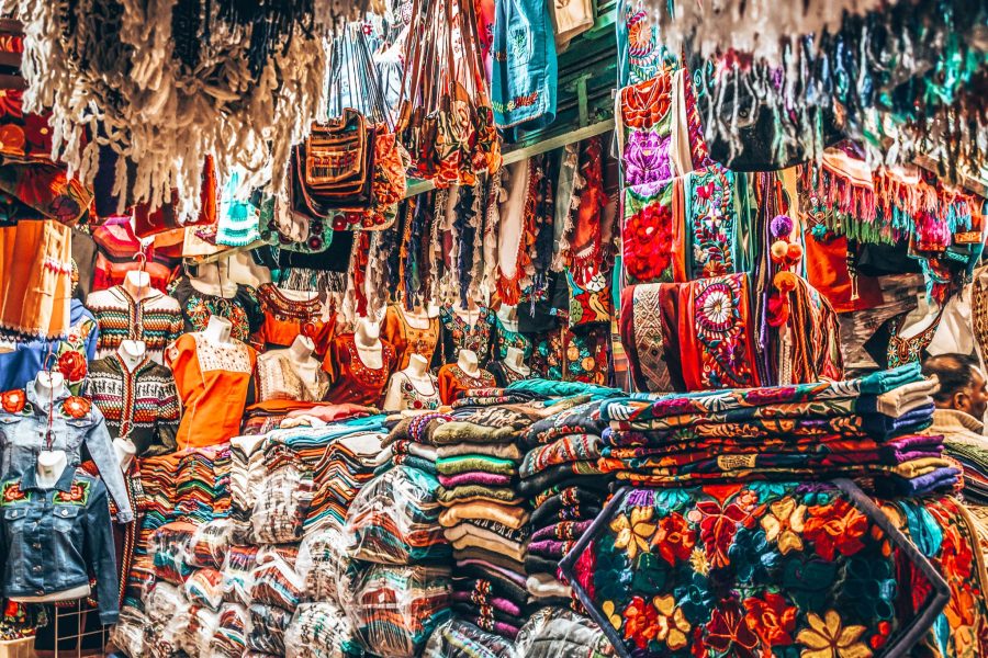 A stall packed with colourful clothes, fabrics and souvenirs at a market, Mexico