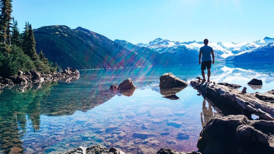 Andy stood looking out across the peaceful Garibaldi Lake with Sphinx Glacier in the background, Garibaldi Provincial Park, British Columbia