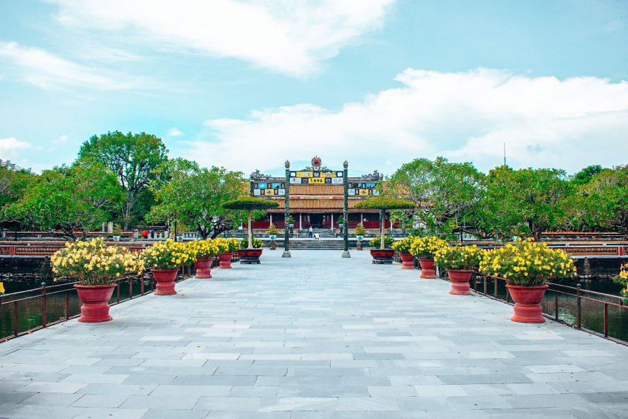 A long pathway lined with flowers and trees leading to Hue Citadel, Vietnam