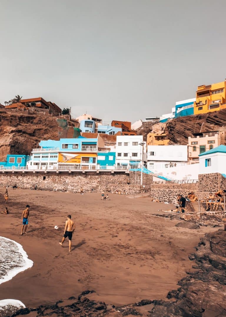 Multi-coloured vibrant buildings climbing up the cliffs behind Sardina del Norte, one of the best places to visit in Gran Canaria