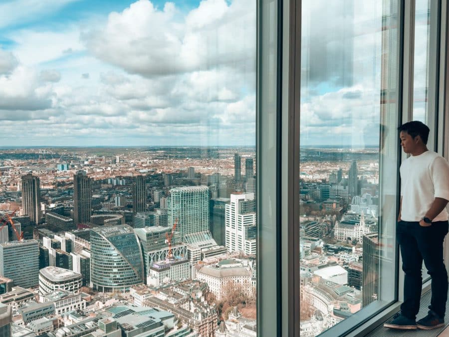 Andy looking out of floor-to-ceiling glass windows across North London, The Lookout at 8 Bishopsgate, best viewpoints in London