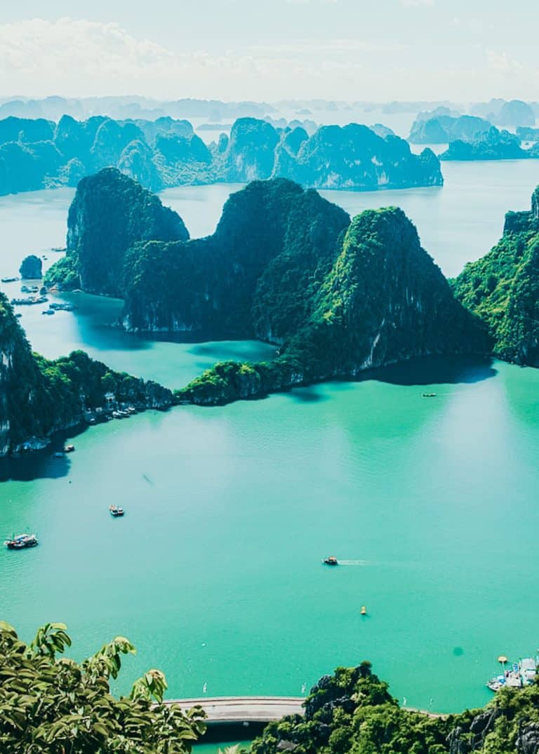 The ocean scattered with multiple magnificent limestone karsts with cruise ships dotted around, Ha Long Bay, best of Vietnam