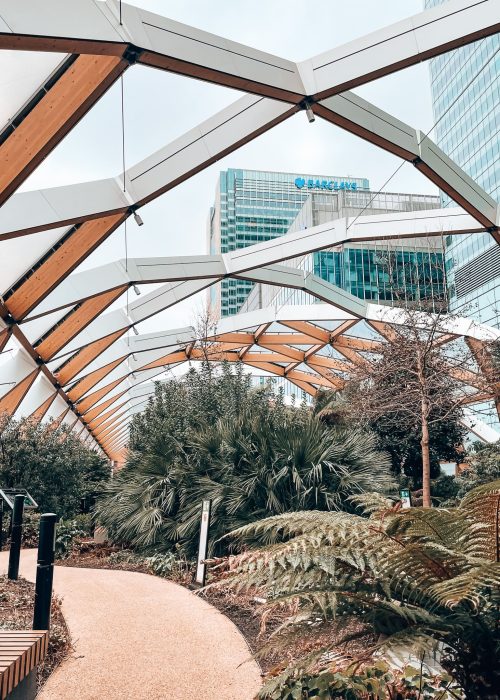 Glitzy skyscrapers of Canary Wharf towering above the glass ceiling of the Crossrail Place Roof Garden, viewpoints in London