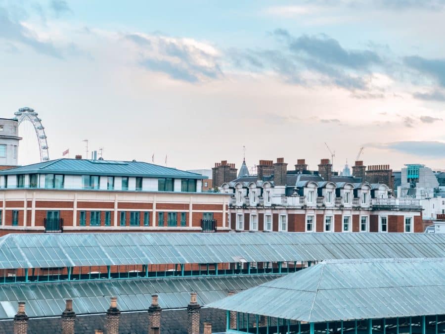 Looking across historical buildings to the London Eye in the background from the Royal Opera House, one of the best free viewpoints in London, Covent Garden