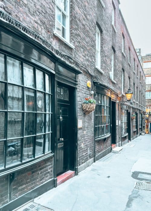 Old bow-fronted cottages line a narrow alley, Goodwin's Court, Covent Garden, London