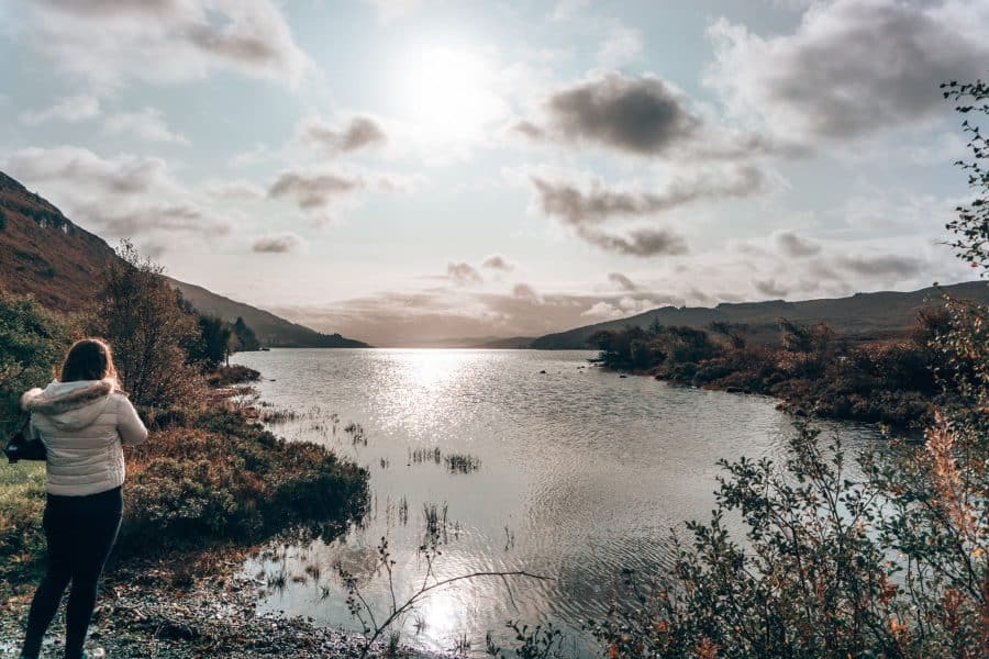 Helen stood on the shore of Loch Frisa with the sun beaming down, beautiful places to visit on Mull, Scotland