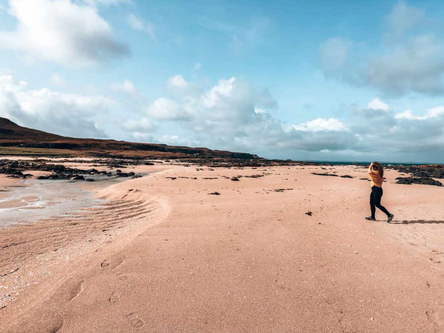 Helen walking across the white sand of unspoiled Langamull Beach on our Isle of Mull itinerary