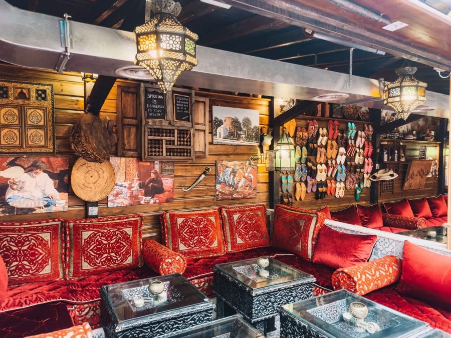 Red velvet cushions on sofas and colourful patterned decorations at Oasis Lounge London, restaurants in North West London