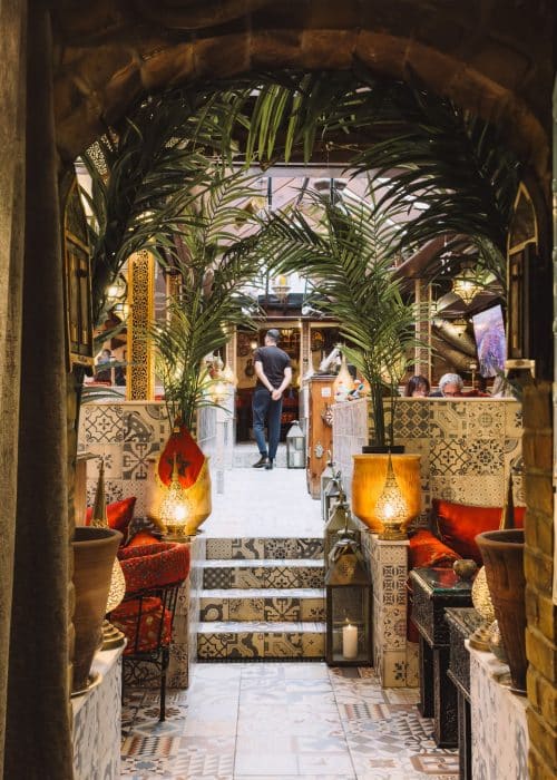 The entrance to the hidden garden at Oasis Lounge London with lamps and plants, best Moroccan restaurants in North London