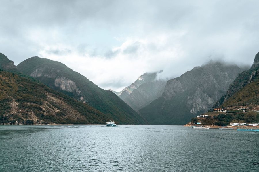 The peaceful Lake Komani surrounded by towering mountains and lakeside villages, Valbona to Theth Hike, Albania