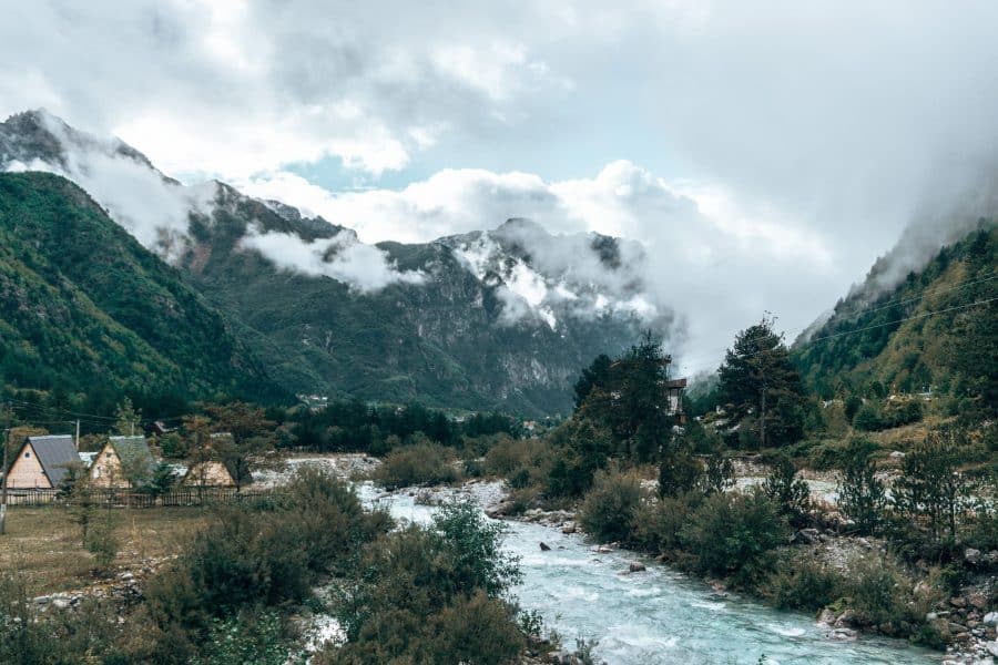 A turquoise gushing river flowing towards the mountains in Theth, Albania