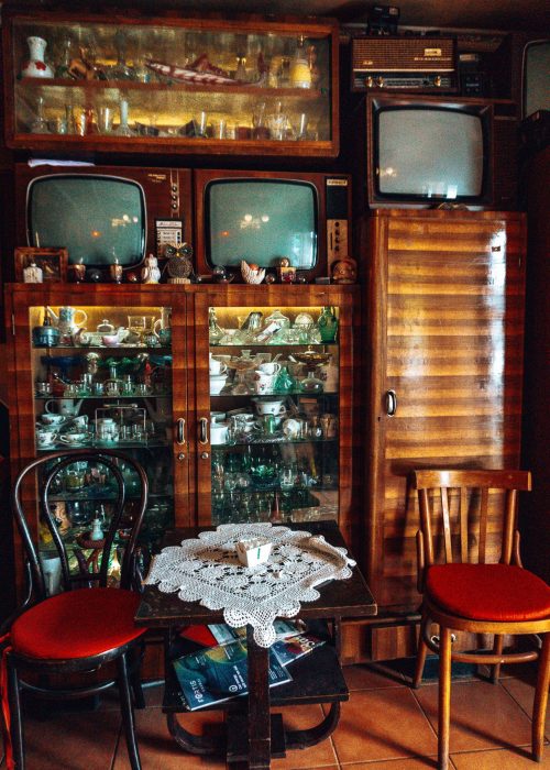 A dimly-lit room full of decor and furniture from the communist era, Kometeti Bar, best things to do in Tirana, Albania