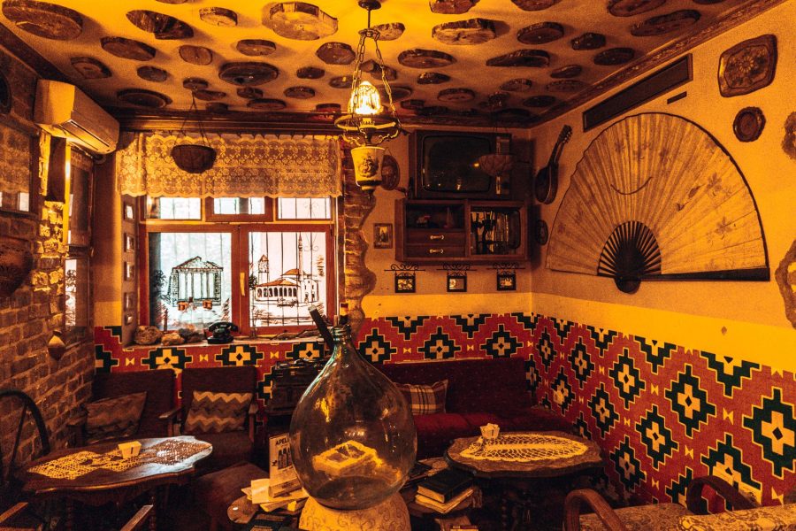 A dimly-lit room full of decor and furniture from the communist era, Kometeti Bar, best things to do in Tirana, Albania