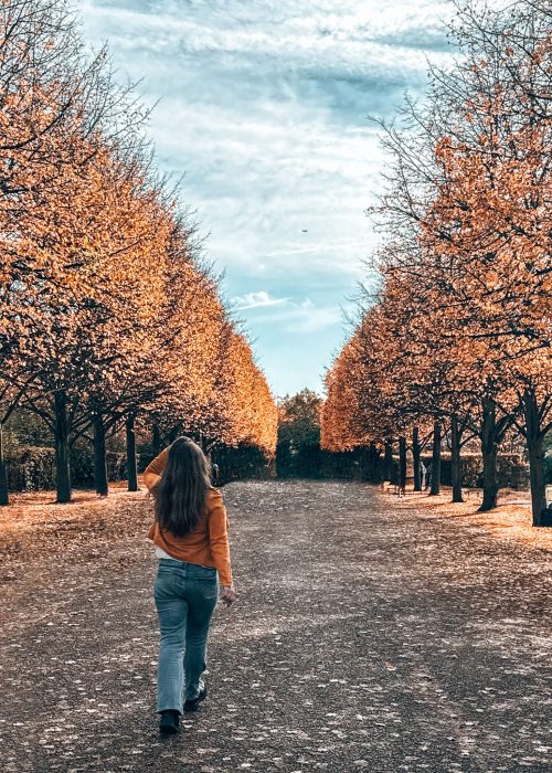 Helen walking down The Broad Walk lined with orange and gold trees in autumn, Regent's Park in Autumn, London Itinerary