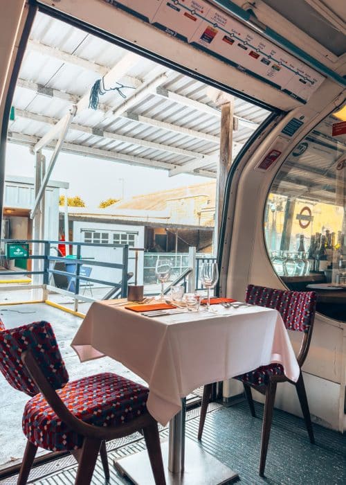 A table of two beautifully set up in a disused tube carriage, Walthamstow Supperclub, 4 days in London