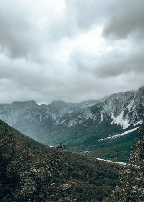 Low clouds draped over towering mountain peaks on the Valbona to Theth Hike, Albania