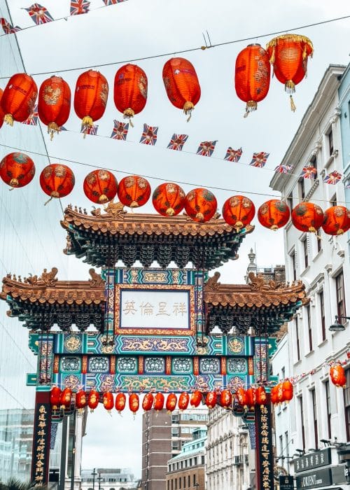 The colourful gates to London Chinatown with red lanterns hanging between the buildings, London itinerary