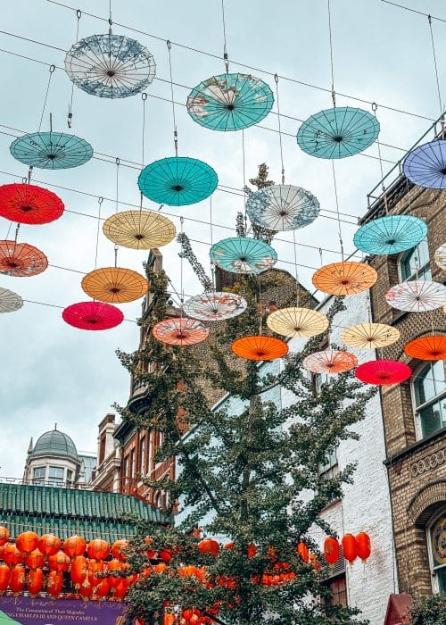 Colourful umbrellas hanging between the buildings in London Chinatown