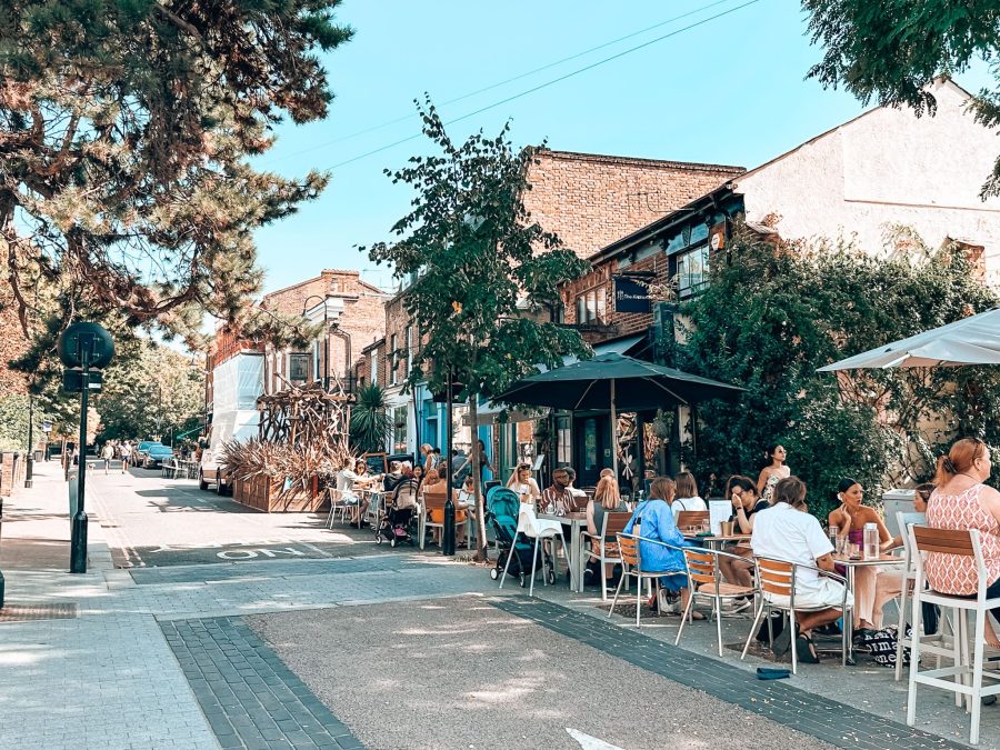 A pedestrianised street lined with cafes and restaurants with outdoor tables, Walthamstow Village, East London Itinerary