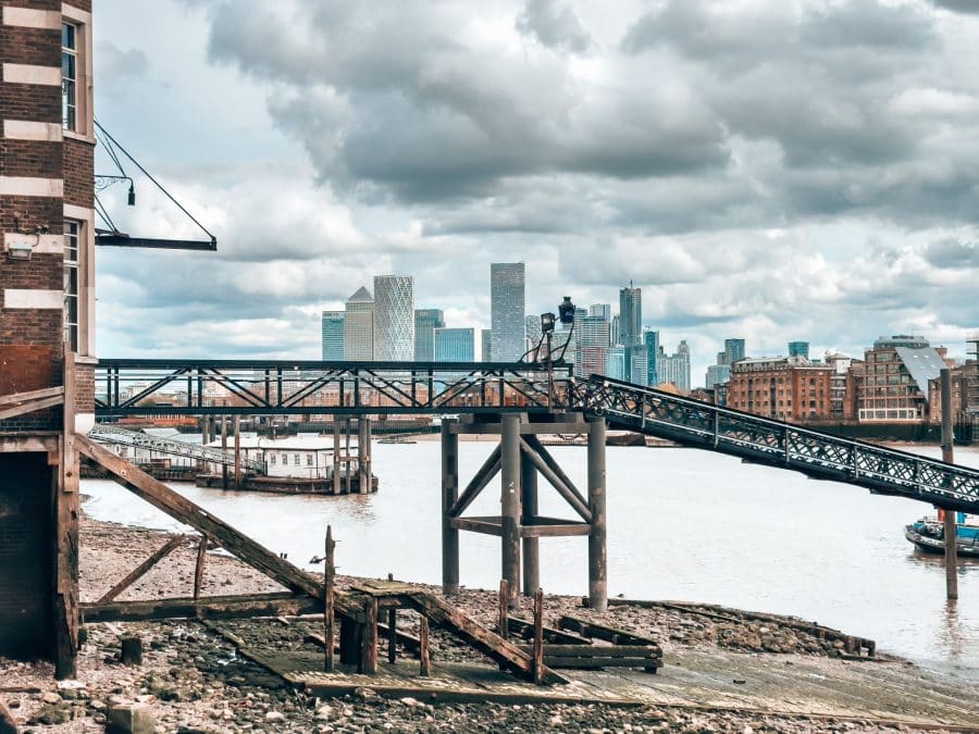 An old Execution Dock on the beach by The Thames with Canary Wharf in the background, London itinerary