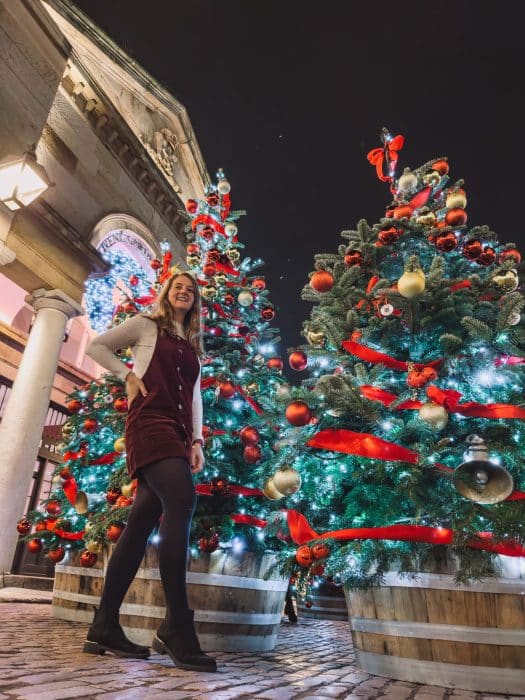 Helen stood in front of several Christmas trees at the Covent Garden Christmas Decorations in London
