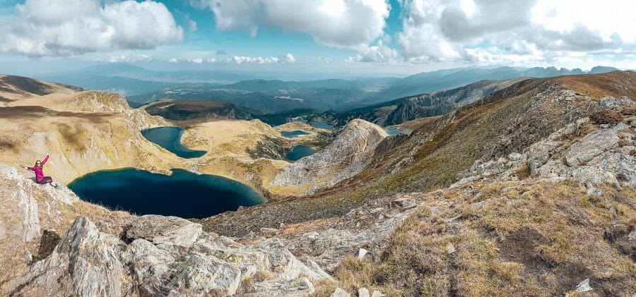 Helen sitting with the view over all of Seven Rila Lakes, best hikes in Bulgaria