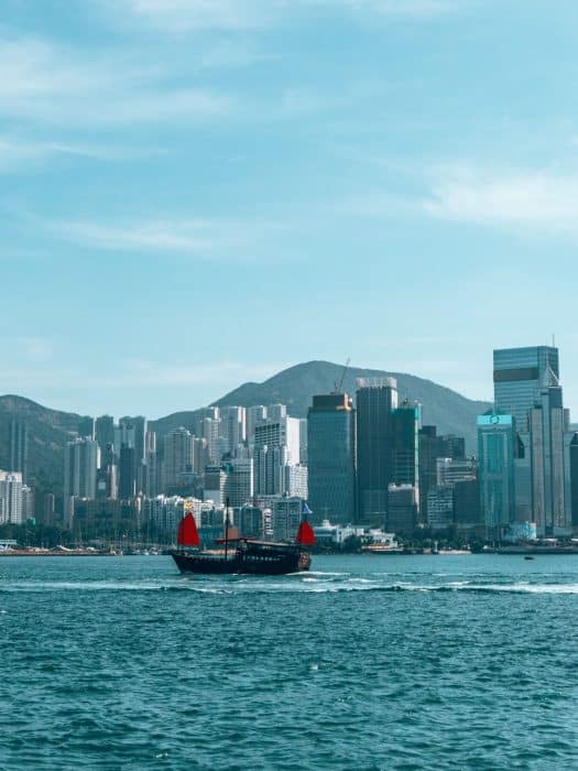 A boat with red sails sailing across Victoria Harbour, Hong Kong