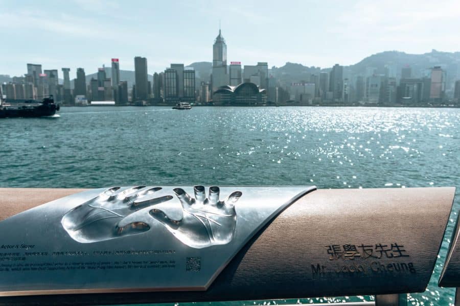 Two handprints on a railing in front of Victoria Harbour with skyscrapers in the distance, Avenue of Stars, Things to do in Hong Kong