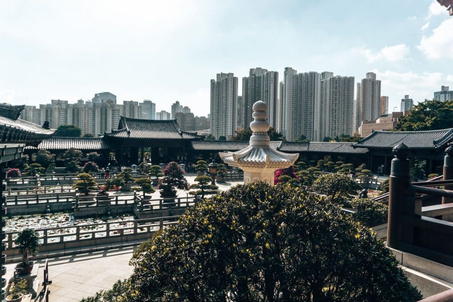 Looking over one of the courtyards of beautifully manicured gardens and greenery with skyscrapers behind, Chi Lin Nunnery and Nan Lian Garden, Hong Kong