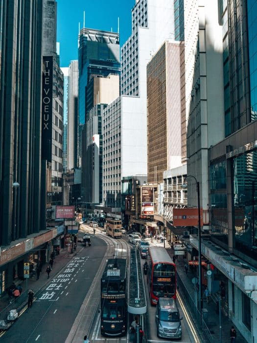 A bus and a tram in between tall skyscrapers on Hong Kong Island