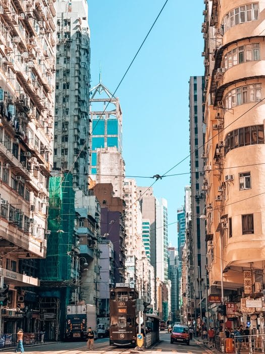 An old tram in between tall skyscrapers on Hong Kong Island