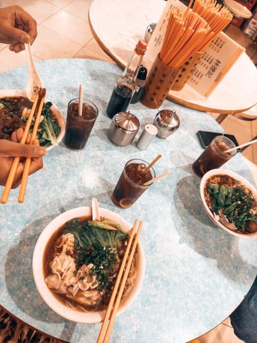 A table with 4 bowls of wonton noodles, best food to eat in Hong Kong